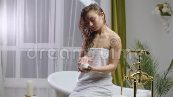 女人的皮肤护理早上用女性手在肘部涂护身霜女人的皮肤护理接近女性视频的预览图