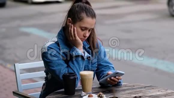 年轻漂亮的女孩在户外喝咖啡视频的预览图