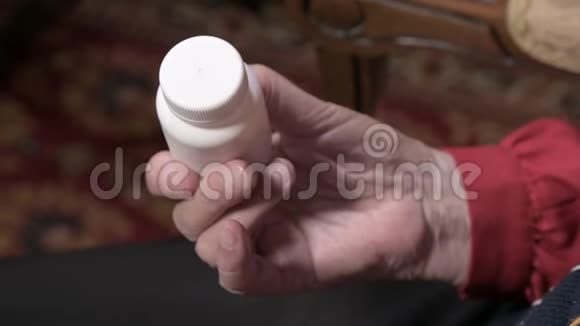 一位老妇人的手打开一个白色罐子里面有欧米茄3药物胶囊和维生素健康概念补充剂视频的预览图