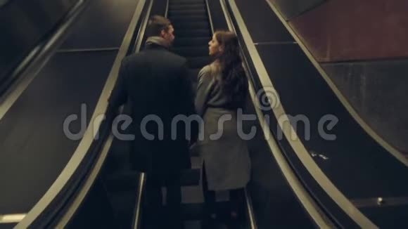 年轻夫妇一起坐在自动扶梯上视频的预览图