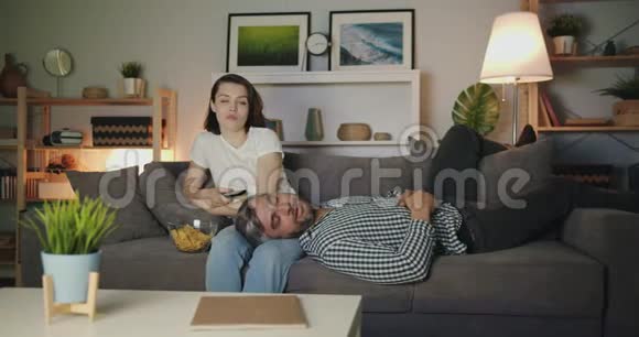 女人看电视吃零食丈夫晚上睡沙发视频的预览图