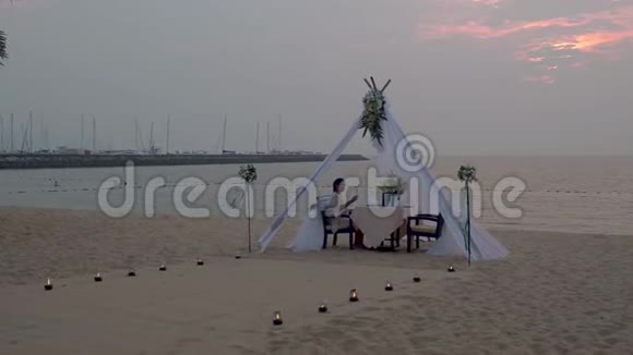 海滩上的浪漫晚餐泰国日落时在海滩上的honemoon晚餐情人节套餐视频的预览图
