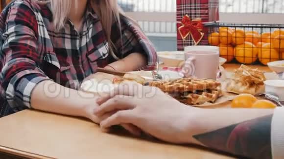 一对可爱的夫妇在咖啡馆吃午饭手牵着桌子视频的预览图