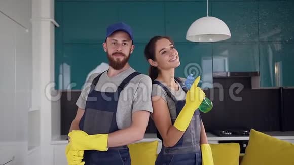 一队身穿蓝色制服的清洁工微笑着站在厨房的中央视频的预览图