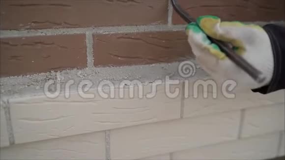 工人擦墙砖工人擦砖间的接缝工人小心地做一堵砖墙特写视频的预览图