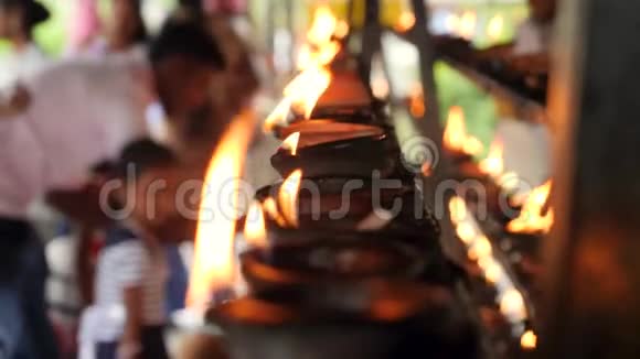 在佛寺祭坛上焚烧油灯和崇拜宗教人士的4k录像视频的预览图