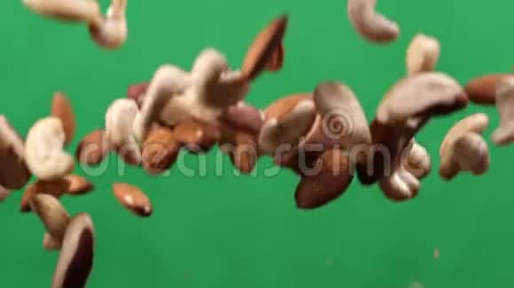 坚果混合物在绿色背景上上下飞行烹饪健康食品与坚果混合视频的预览图