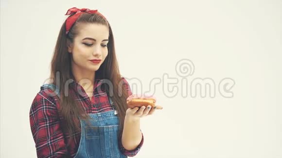 快乐的小女孩拿着大甜甜圈拿着糖霜的手指舔它视频的预览图
