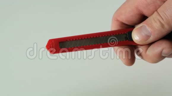 红色文具刀在男性手中打开和关闭视频的预览图