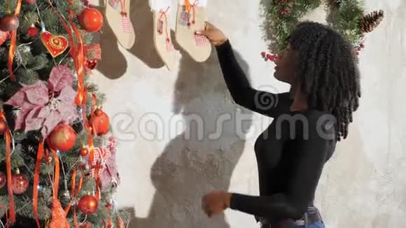 微笑的黑人女孩用红球装饰圣诞树视频的预览图