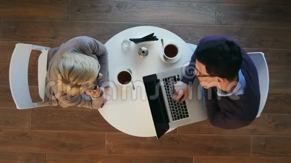 伴侣们喜欢在明亮的现代咖啡馆工作女人打电话男人在笔记本电脑上工作视频的预览图