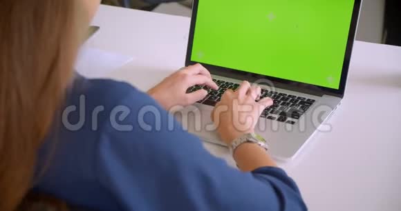 特写后景照片年轻迷人的白种人女商人在室内使用带有绿色屏幕的笔记本电脑视频的预览图