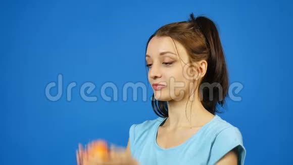 微笑的女人健康的牙齿吃红苹果在蓝色背景在工作室减肥的概念素食视频的预览图