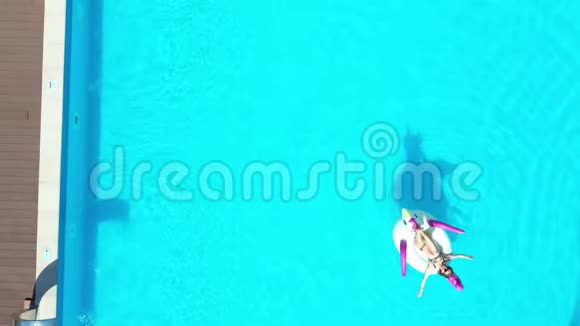 空中射击穿比基尼的女孩和戴着充气床垫的太阳镜在游泳池里游泳视频的预览图
