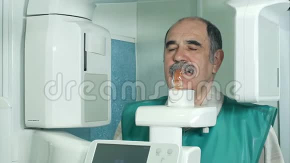 使用全景和头影X射线扫描仪检查牙齿的资深病人视频的预览图
