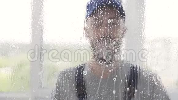 用蓝色均匀的男性胡须清洁剂用清洁剂喷雾和特殊的刮刀清洗窗户视频的预览图