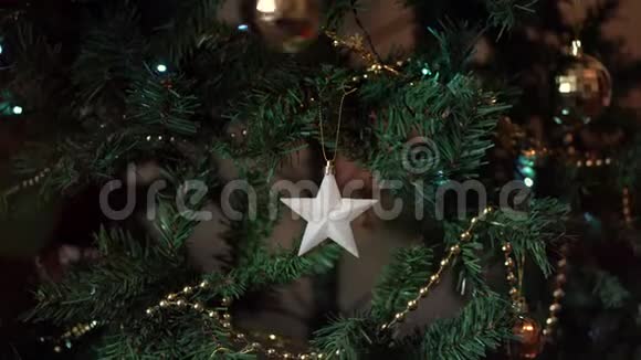 特写一个女人手在圣诞树上挂球的镜头视频的预览图