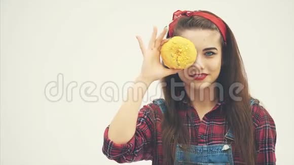 可爱的皮夹女孩正把眼睛藏在大黄的后面然后是粉红色的甜甜圈抬起眉毛微笑着视频的预览图
