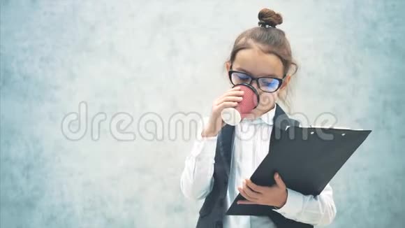 一个灰色背景的女商人阅读文件夹中的重要信息是喝咖啡视频的预览图