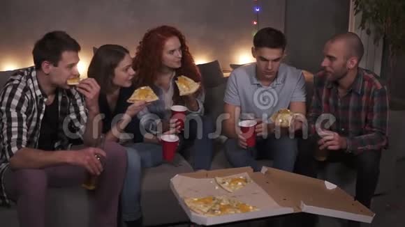 年轻人快乐的男人和女人正在吃奶酪披萨在公寓的室内聚会上聊天放松视频的预览图