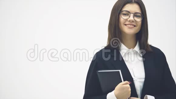 成功的女商人拿着黑色笔记本摆姿势微笑视频的预览图