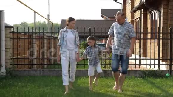 爸爸和漂亮的妈妈牵着快乐的小男孩的手视频的预览图