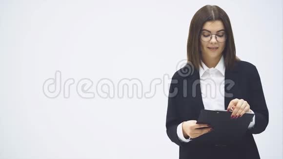 一个穿着西装穿着西装手里拿着纸架站着说话展示着某种东西的有魅力的女商人视频的预览图