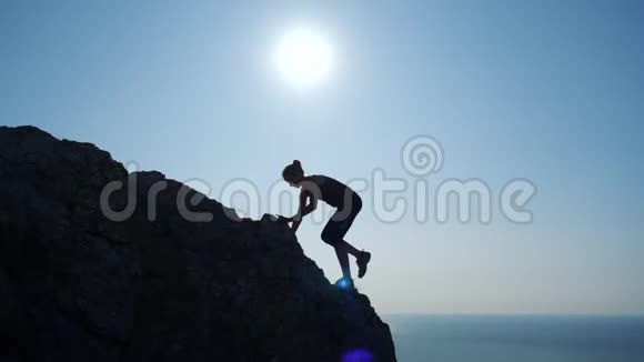 年轻女子缓慢地向山顶走去一位女士在美丽的克里米亚山区徒步旅行的剪影视频的预览图