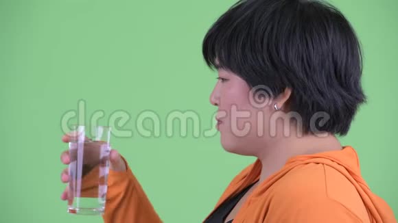 近距离观看快乐年轻超重的亚洲女性为健身房准备的饮用水视频的预览图
