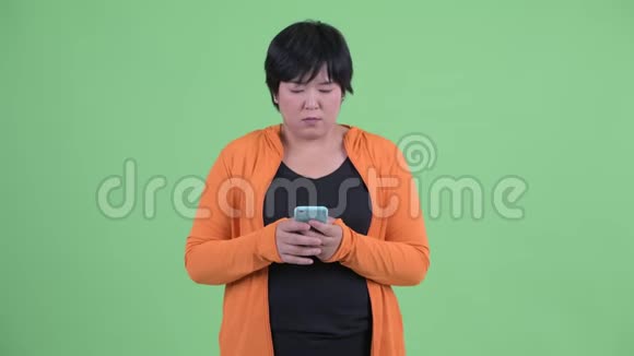 快乐的年轻超重的亚洲女人用电话打出租车准备健身房视频的预览图