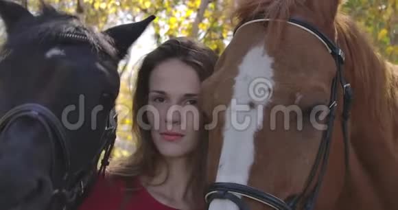 一个皮肤有问题的白人女孩站在户外两匹马的肖像接受嬉皮士治疗的患病妇女视频的预览图