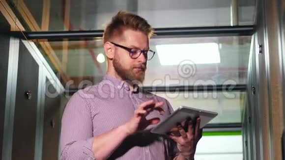 一个留着平板电脑的胡子男人在服务器房视频的预览图