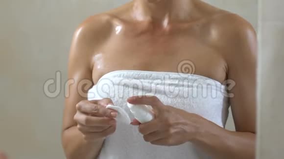 女人在浴室淋浴后在脸上涂润肤露护肤视频的预览图