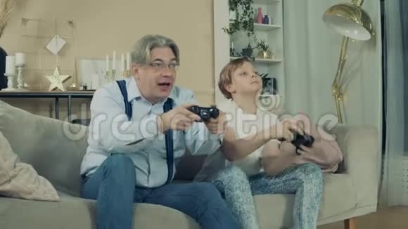 祖父和一个十几岁的男孩一起在视频游戏中获胜视频的预览图