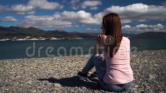 坐在海滩上看着大海的年轻女孩心烦意乱女孩和男朋友分手了现在视频的预览图
