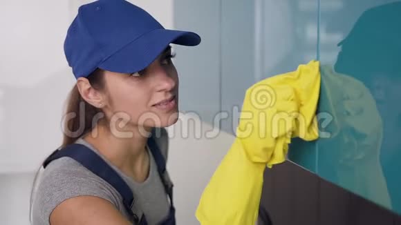 穿着制服戴着黄手套的清洁服务部门漂亮的年轻女工在厨房里扭动视频的预览图