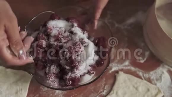 女人手把樱桃和糖搅拌起来烘烤视频的预览图
