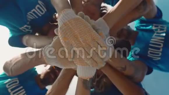 团体志愿者把他们的双手放在一起作为团结和团队合作的象征视频的预览图