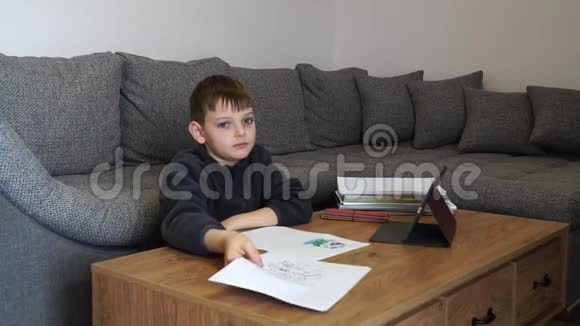 学习上的困难悲伤疲惫沮丧的男孩坐在桌子旁拿着许多书拿着纸用单词帮助教育c视频的预览图
