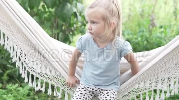 夏天坐在农场吊床上的小女孩视频的预览图