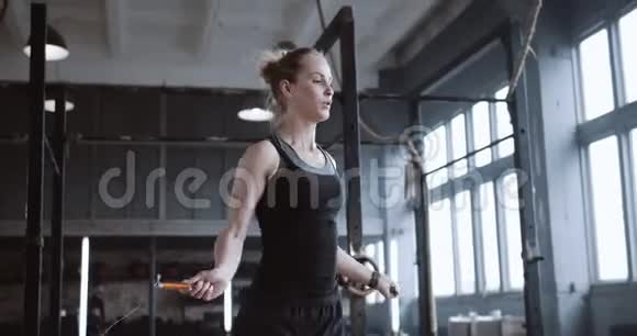特写年轻漂亮的金发女人用跳绳锻炼在大型大气健身房锻炼慢动作视频的预览图