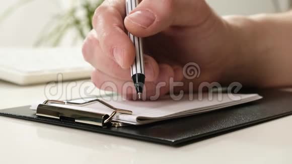 手躺在桌子上拿着铅笔写字特写镜头视频的预览图