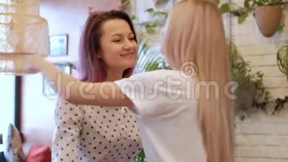 两个年轻漂亮的女孩朋友在咖啡馆见面拥抱视频的预览图