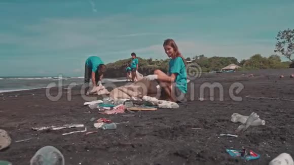 志愿者清洁海滩使用生态袋整理海滩上的塑料视频的预览图