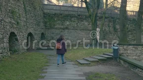 年轻女子穿过古老的中世纪公园博加莫米兰视频的预览图