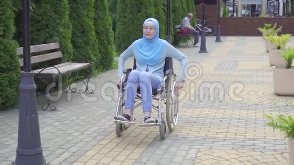 一位戴头巾坐轮椅的穆斯林美女的肖像视频的预览图