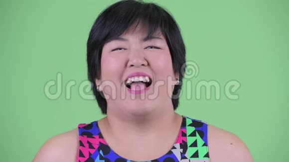 一脸快乐的年轻肥胖的亚洲女人笑着准备聚会视频的预览图