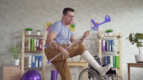 在康复中心一个穿着绷带的腿拄着拐杖跳舞的的男人视频的预览图