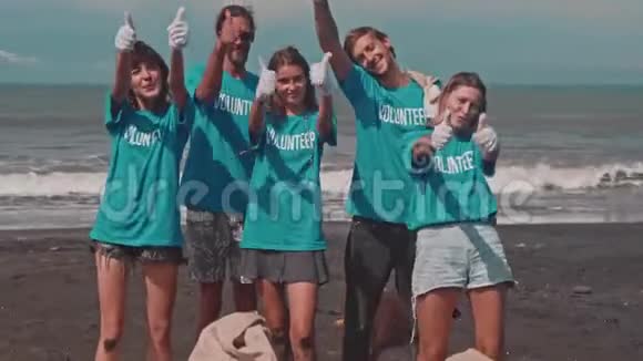 志愿者们在海边竖起大拇指庆祝胜利视频的预览图