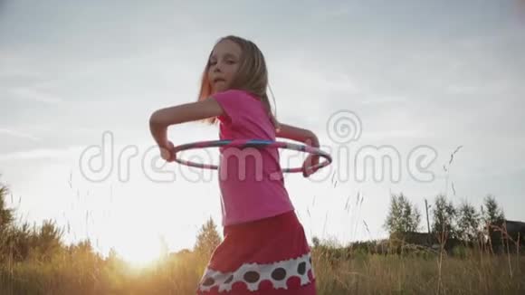 日落时分小女孩在腰上扭一个体育圈视频的预览图